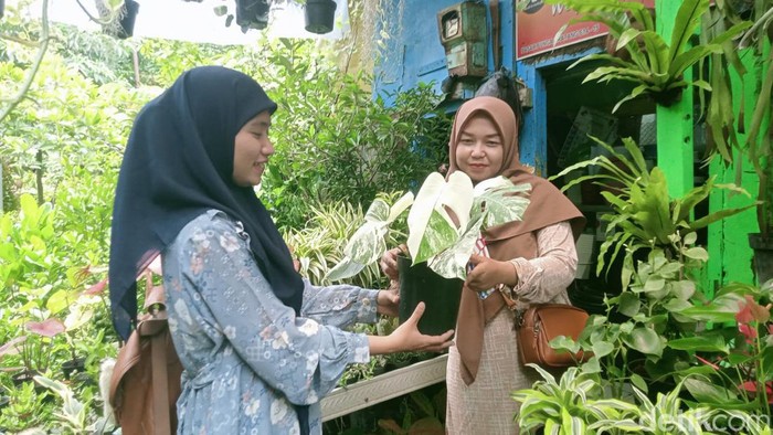 Diah Oktaviani (kanan) pedangang bunga saat melayani pembeli di stannya Pasar Bratang