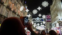 Seorang warga memotret tampilan lampu yang menyala dalam perayaan awal Ramadhan, di London, Inggris, 7 Maret 2024.  