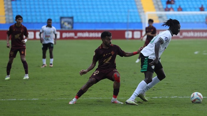 Pemain PSM Makassar Yakob Sayuri berduel dengan striker PSS Sleman Ajak Riak dalam laga pekan ke-28 Liga 1 di Stadion Batakan.