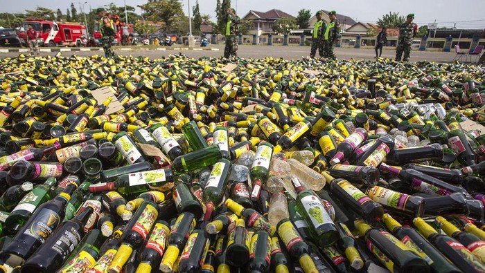 Prajurit TNI mengumpulkan botol miras hasil sitaan menjelang pemusnahan di Indramayu, Jawa Barat, Jumat (8/3/2024). Dinas Satpol PP dan Pemadam Kebakaran Kabupaten Indramayu memusnahkan ribuan botol minuman keras berbagai merek dalam rangka menciptakan suasana kondusif jelang Ramadan. ANTARA FOTO/Dedhez Anggara.