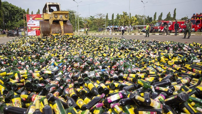 Prajurit TNI mengumpulkan botol miras hasil sitaan menjelang pemusnahan di Indramayu, Jawa Barat, Jumat (8/3/2024). Dinas Satpol PP dan Pemadam Kebakaran Kabupaten Indramayu memusnahkan ribuan botol minuman keras berbagai merek dalam rangka menciptakan suasana kondusif jelang Ramadan. ANTARA FOTO/Dedhez Anggara.