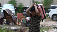 Warga korban banjir bandang mengangkat tas untuk mengungsi di Kelurahan Kasilampe, Kendari, Sulawesi Tenggara, Kamis (7/3/2024).