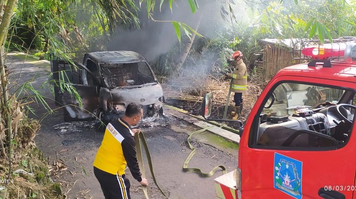 Petugas gabungan memadamkan mobil pikap yang terbakar di Pakem, Sleman, Jumat (8/3/2024).