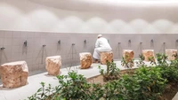 Bagian ruang wudhu. Terdapat tempat duduk yang terlihat seperti terbuat dari bebatuan. Foto: Firas Al Raisi via Dezeen