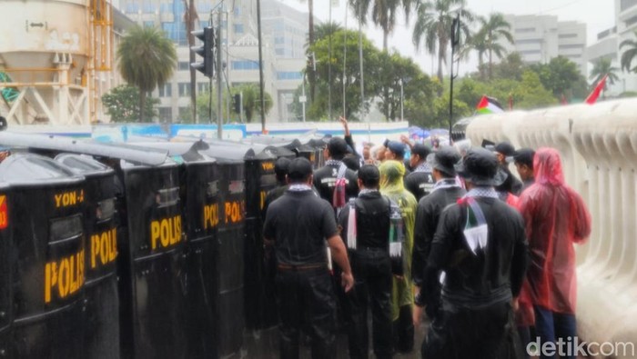 Sambil hujan-hujanan, massa aksi bela Palestina berdemo di Kedubes AS (Rumondang/detikcom).