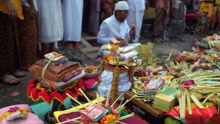 Tradisi Mesuryak Hari Raya Kuningan Pemuka agama Hindu berdoa dengan sesajen berisi uang saat tradisi Mesuryak di Desa Bongan Gede, Tabanan, Bali, Sabtu (9/3/2024). Tradisi yang digelar setiap Hari Raya Kuningan sebagai rasa suka cita untuk mengantarkan roh para leluhur kembali ke surga tersebut disaksikan wisatawan domestik dan mancanegara yang berkunjung ke desa itu. ANTARA FOTO/Nyoman Hendra Wibowo/nz