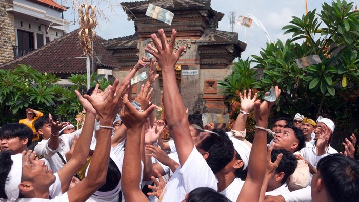 Pemuka agama Hindu berdoa dengan sesajen berisi uang saat tradisi Mesuryak di Desa Bongan Gede, Tabanan, Bali, Sabtu (9/3/2024). Tradisi yang digelar setiap Hari Raya Kuningan sebagai rasa suka cita untuk mengantarkan roh para leluhur kembali ke surga tersebut disaksikan wisatawan domestik dan mancanegara yang berkunjung ke desa itu. ANTARA FOTO/Nyoman Hendra Wibowo/nz