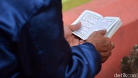 Salah satu peziarah nampak khusuk membacakan surat yasin di tempat Pemakaman Umum Tembok Gede.
