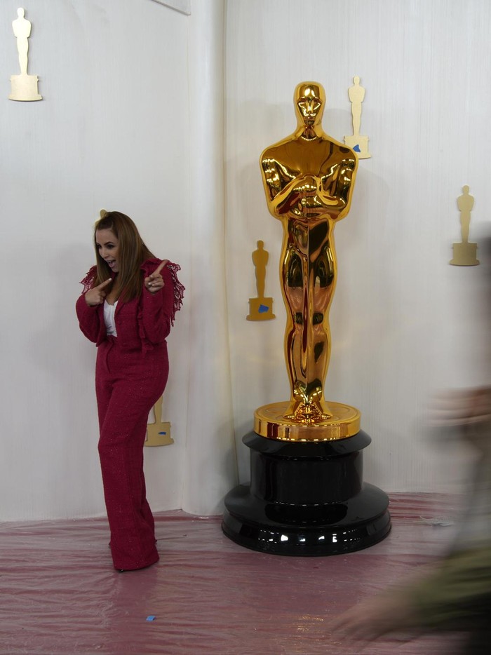 Persiapan Karpet Merah Oscars 2024 People walk by an Oscars statue on the red carpet ahead of the 96th Academy Awards, Thursday, March 7, 2024, in Los Angeles. (AP Photo/John Locher)
