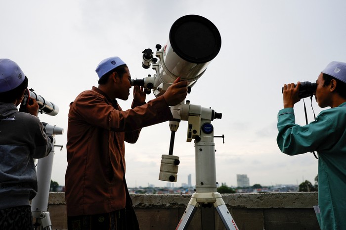 Muslim men look for the position of the moon to mark the first day of the holy fasting month of Ramadan, on the roof of Al-Musyariin mosque in Jakarta, Indonesia, March 10, 2024. REUTERS/Willy Kurniawan