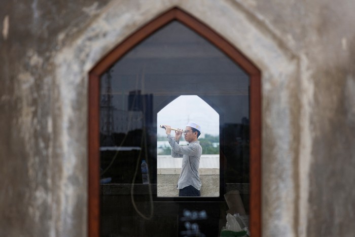 Muslim men look for the position of the moon to mark the first day of the holy fasting month of Ramadan, on the roof of Al-Musyariin mosque in Jakarta, Indonesia, March 10, 2024. REUTERS/Willy Kurniawan