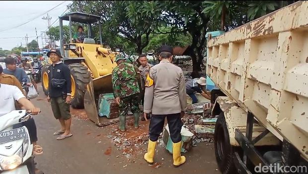 Warga Dringu, Probolinggo mulai membersihkan sisa banjir.