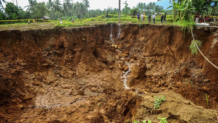Akses Jalan Antardesa Ambles di Pandeglang Warga melihat kondisi jalan yang ambles di Desa Cilabanbulan, Pandeglang, Banten, Senin (11/3/2024). Hujan deras yang terjadi di kawasan tersebut mengakibatkan jalan poros desa Cilabanbulan-Ciherang ambles sedalam 15 meter hingga menyebabkan akses jalan terputus dan tidak bisa dilalui kendaraan roda empat dan roda dua. ANTARA FOTO/Muhammad Bagus Khoirunas/foc.
