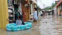 Seorang anak bermain di banjir luapan Sungai Bengawan Solo/Foto: Ainur Rofiq/detikJatim
