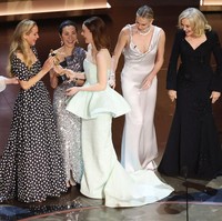 Emma Stone sempat panik dan memegangi bagian belakang gaunnya saat naik ke atas panggung Oscars 2024. Foto: Rich Polk/Variety via Getty Images