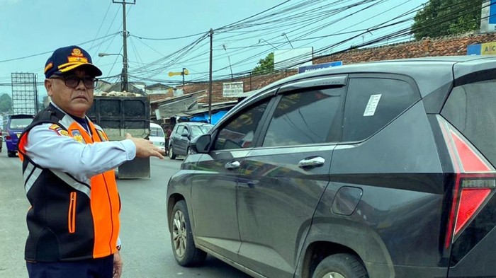 Petugas Dishub tengah mengatur lalu lintas.