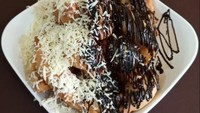Pisang molen dengan topping cokelat dan keju juga bisa ditemukan di Molenesia. Lokasinya ada di kawasan Parigi Baru, Pondok Aren, Tangerang. Sajiannya ditawarkan per porsi dengan harga Rp 23.500. Foto: Google Review