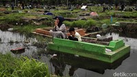 Warga berziarah di TPU Semper yang terendam banjir. 