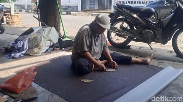 R Rahman ketika membuat pola untuk sepatu produksi Chaniago Jaya. (Andika Syahputra/detikcom)