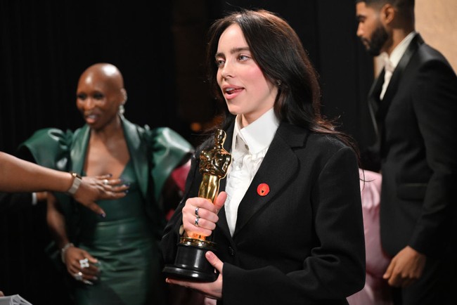 Salah satu yang mencuri atensi dari penampilan Billie Eilish di Oscars 2024 adalah pin merah yang dipakainya di bagian dada blazernya. Dia memakai pin Artists4Ceasefire. Aksesori tersebut merepresentasikan kumpulan para bintang dan pelaku industri hiburan Hollywood yang mendukung gencatan senjata perang Israel-Hamas di Gaza, Palestina.  Foto: Richard Harbaugh/A.M.P.A.S. via Getty Images