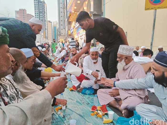 Seorang pria membagikan susu kepada jemaah di Masjidil Haram untuk berbuka puasa, Senin (11/3/2024).