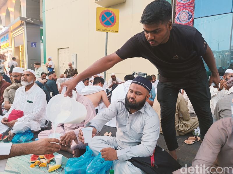 Seorang pria membagikan susu kepada jemaah untuk buka puasa di Masjidil Haram, Senin (11/3/2024).