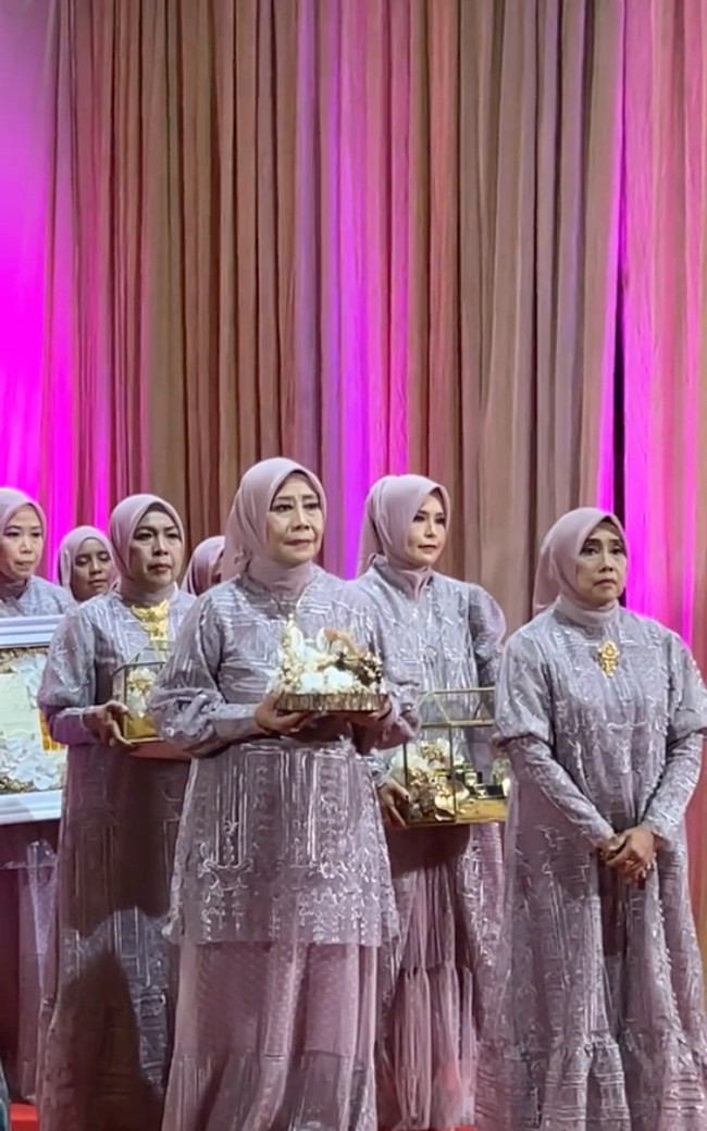 Keluarga dari calon mempelai pria hadir dengan mengenakan busana berwarna dusty pink. Anggota keluarga Kapten Rully itu masuk dengan membawa aneka seserahan untuk Dewi Perssik. Foto: TikTok/@antv_official