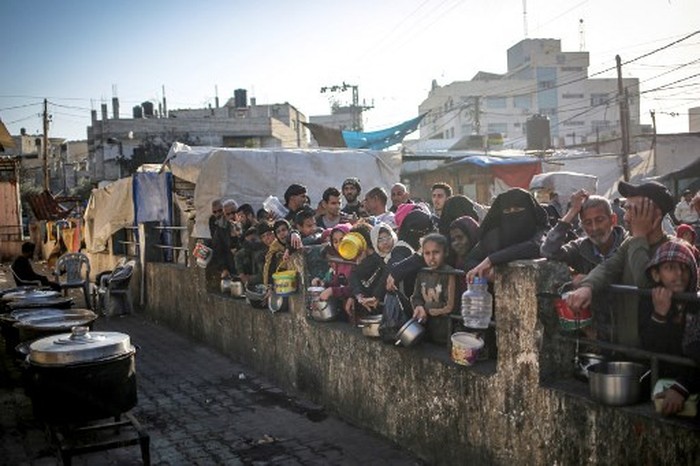 The Palestinian Al-Naji family eats an iftar meal, the breaking of fast, amidst the ruins of their family house, on the first day of the Muslim holy fasting month of Ramadan, in Deir el-Balah in the central Gaza Strip on March 11, 2024, amid ongoing battles between Israel and the militant group Hamas. (Photo by AFP)