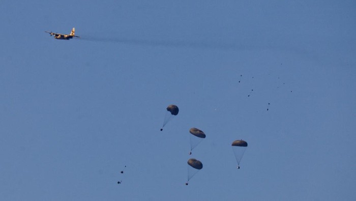 Potret Langit Gaza Dihujani Bantuan Kemanusiaan Packages fall towards northern Gaza, after being dropped from an Egyptian military aircraft, amid the ongoing conflict between Israel and the Palestinian group Hamas, as seen from Israel's border with Gaza, in southern Israel, March 10, 2024. REUTERS/Amir Cohen