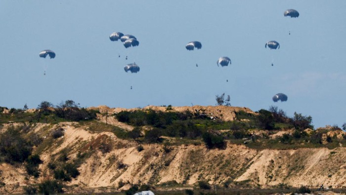 Potret Langit Gaza Dihujani Bantuan Kemanusiaan Packages fall towards northern Gaza, after being dropped from an Egyptian military aircraft, amid the ongoing conflict between Israel and the Palestinian group Hamas, as seen from Israel's border with Gaza, in southern Israel, March 10, 2024. REUTERS/Amir Cohen