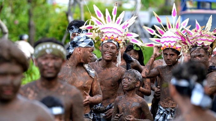 Potret Tradisi Mebuug-buugan, Mandi Lumpur Setelah Nyepi Sejumlah warga yang tubuhnya dilumuri lumpur berjalan berkeliling kampung saat mengikuti tradisi Mebuug-Buugan di kawasan Kedonganan, Badung, Bali, Selasa (12/3/2024). Tradisi Mebuug-Buugan atau mandi lumpur itu dilakukan ratusan warga setempat sebagai simbol untuk menghilangkan kekotoran dan hal-hal negatif setelah Hari Raya Nyepi Tahun Saka 1946. ANTARA FOTO/Fikri Yusuf/aww.