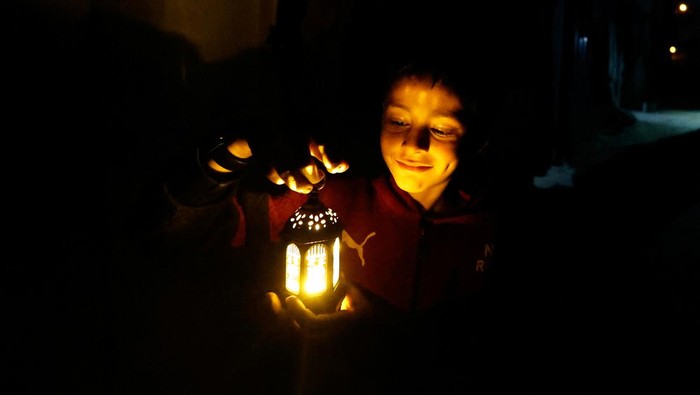 A child holds a lantern as displaced Palestinians prepare their tents for Ramadan, amid the ongoing conflict between Israel and the Palestinian Islamist group Hamas, in Rafah, in the southern Gaza Strip March 9, 2024. REUTERS/Mohammed Salem