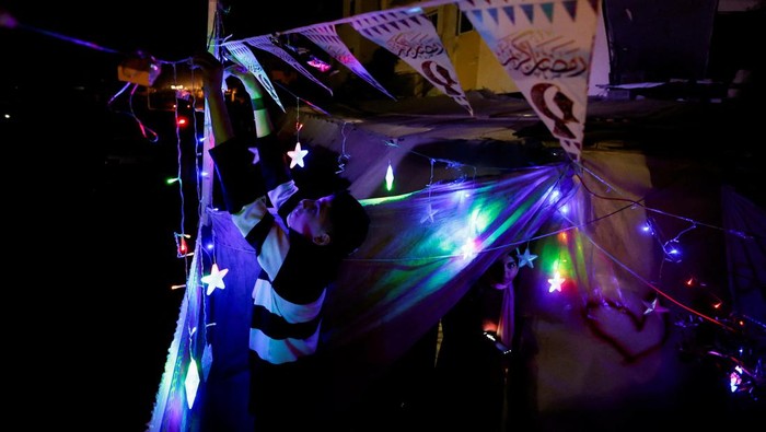 A child holds a lantern as displaced Palestinians prepare their tents for Ramadan, amid the ongoing conflict between Israel and the Palestinian Islamist group Hamas, in Rafah, in the southern Gaza Strip March 9, 2024. REUTERS/Mohammed Salem