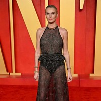 Charlize Theron tampil cantik mengenakan gaun hitam transparan dengan garis leher halter yang dihiasi glitter berkilauan. Foto: Getty Images/Lionel Hahn