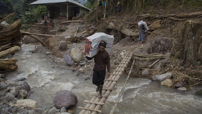Akses Menuju Lokasi Bencana Sumbar Terputus, Warga Minta Bantuan Warga memanggul karung berisi bantuan untuk korban banjir bandang dan longsor di Langgai, Gantiang Mudiak Utara Surantiah, Kecamatan Sutera, Pesisir Selatan, Sumatera Barat, Selasa (12/3/2024). Akses menuju lokasi bencana tersebut putus dan warga yang terdampak mengharapkan bantuan berupa kebutuhan untuk ibu dan anak serta perbaikan jaringan listrik yang terputus ke desa mereka. ANTARA FOTO/Givo Alputra/Lmo/aww.