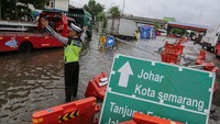 Polis mengatur lalu lintas kendaraan yang macet akibat banjir yang merendam jalur pantura di Jalan Kaligawe Raya, Semarang, Jawa Tengah, Rabu (13/3/2024).