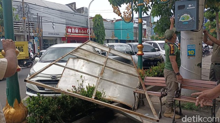 Papan reklame di Kota Malang jatuh timpa mobil