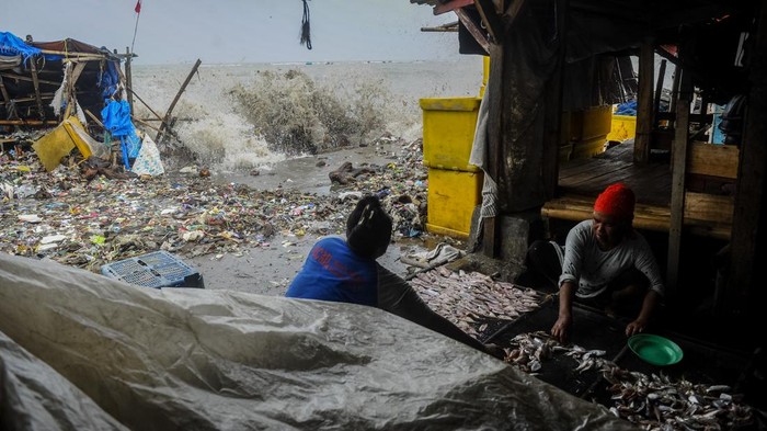 Warga menghindari gelombang tinggi di Teluk Labuan, Pandeglang, Banten, Rabu (13/3/2024). Gelombang tinggi yang terjadi di perairan Selat Sunda sejak sepekan terakhir mengakibatkan puluhan warung rusak dan sampah rumah tangga yang terbawa gelombang menumpuk di pesisir teluk. ANTARA FOTO/Muhammad Bagus Khoirunas/rwa.