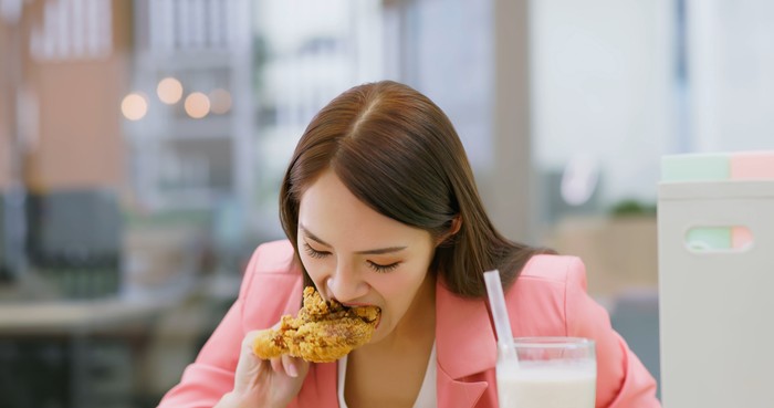 asian busy business woman is eating her lunch and tapioca ball tea while she working in office