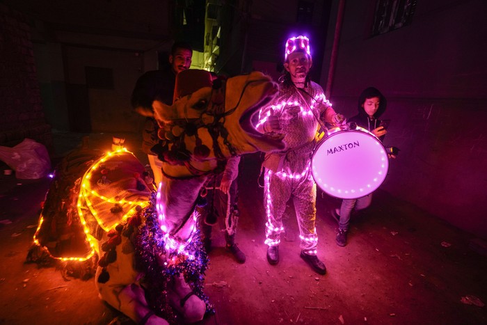 Mohammed El-Dahshan, a 39-year-old Mesaharati, or dawn caller, prepares his camel wrapped with colored led lights to wake Muslims up for a meal before sunrise, during the Islamic holy month of Ramadan, in the Delta city of Dikernis, Egypt, about 93 miles (150 kilometers) north of Cairo, early Thursday, March 14, 2024. Each night, El-Dahshan, sets out after midnight with his camel banging his drum, chanting traditional religious phrases and calling out on residents by name to wake them in time for the vital pre-dawn meal known as Suhoor. (AP Photo/Amr Nabil)