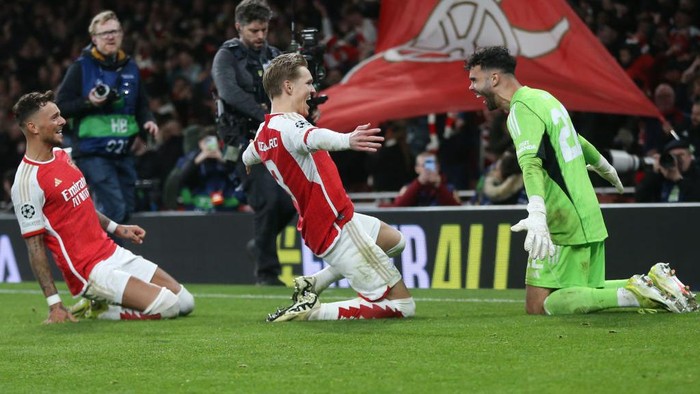 LONDON, ENGLAND - MARCH 12: Arsenals David Raya, Martin Odegaard  and Ben White celebrate after winning the penalty shoot-out during the UEFA Champions League 2023/24 round of 16 second leg match between Arsenal FC and FC Porto at Emirates Stadium on March 12, 2024 in London, England.(Photo by Rob Newell - CameraSport via Getty Images)