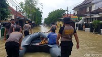 Petugas kepolisian menggunakan perahu karet untuk mengevakuasi warga korban banjir di Sampang.