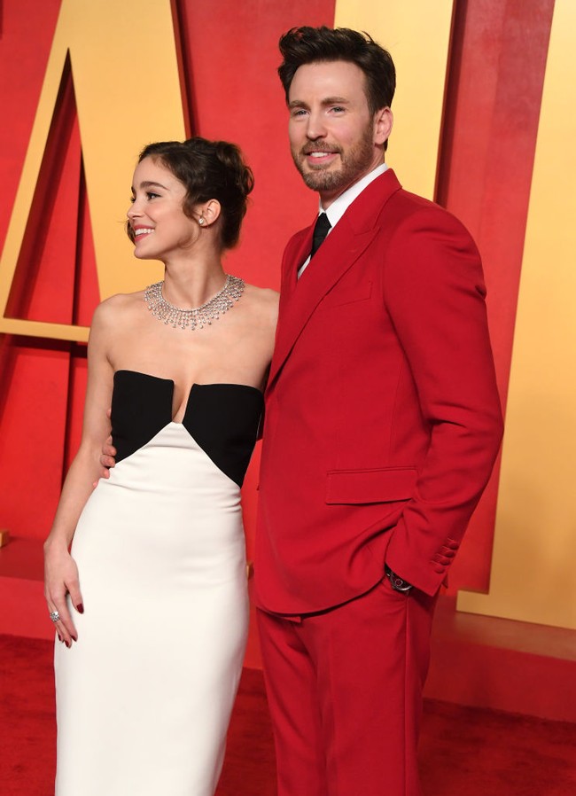 Aktris 26 tahun ini menata rambutnya dengan gaya updo yang apik dan aksen poni bergelombang. Bibirnya dipulas lipstik merah terang, begitu pula kuteks yang menghiasi kuku-kukunya. Foto: Steve Granitz/Getty Images