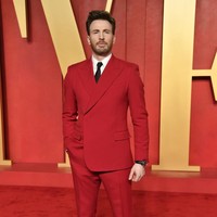 Chris Evans tampil ‘serasi’ dengan karpet merah dalam setelan jas merah dari koleksi Dolce & Gabbana. Jas model double-breasted itu dipasangkan dengan kemeja putih dan dasi sutera hitam. Foto: Evan Agostini/Invision/AP