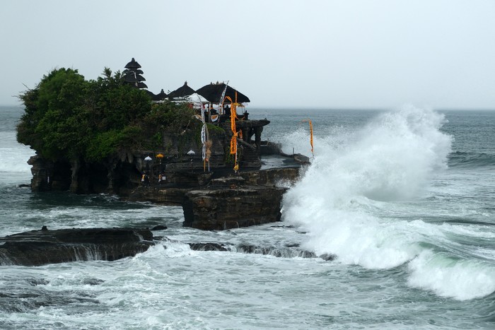 Wisatawan berjalan di dekat papan larangan di objek wisata Tanah Lot, Tabanan, Bali, Kamis (14/3/2024). Badan Meteorologi, Klimatologi, dan Geofisika (BMKG) Wilayah III Denpasar memprediksi terjadinya cuaca ekstrem di wilayah Bali selama tiga hari pada 14-16 Maret 2024 yang merupakan dampak dari terbentuknya bibit siklon tropis 91S dan 94S di wilayah Indonesia. ANTARA FOTO/Nyoman Hendra Wibowo/rwa.