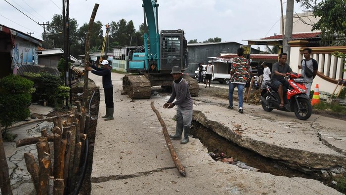 Desa di Bojongmangu Bekasi Rusak Terdampak Tanah Bergerak Foto udara pekerja menggunakan alat berat memperbaiki Jalan Raya Sukamukti yang terdampak tanah bergerak di Desa Sukamukti, Bojongmangu, Kabupaten Bekasi, Jawa Barat, Rabu (13/3/2024). Menurut warga telah tiga hari akses Jalan Raya Sukamukti - Sukabungah tidak bisa dilewati kendaraan roda empat dan puluhan rumah tidak bisa tempati lagi karena kondisinya yang sudah tidak layak karena terdampak tanah bergerak. ANTARA FOTO/Fakhri Hermansyah/tom.