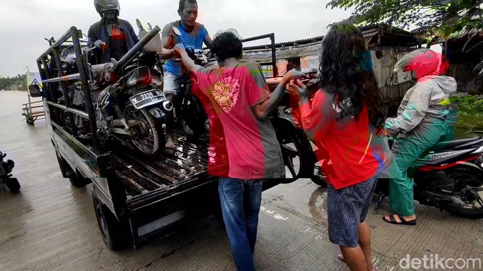 Jasa ojek sepeda motor untuk melewati jalur Jakenan Pati yang kebanjiran, Kamis (14/3/2024).