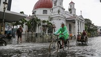 Warga mengayuh sepeda dan becak untuk menembus banjir yang merendam di ruas jalan GPIB Immanuel (Gereja Bleduk) kawasan Cagar Budaya Nasional Kota Lama Semarang, Jawa Tengah, Kamis (14/3/2024).