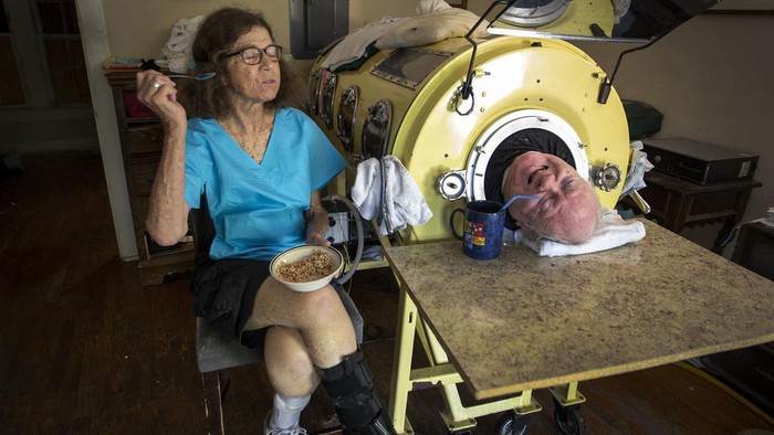 FILE -  In this Friday, April 27, 2018 photo, caregiver and friend Kathryn Gaines washes the face of attorney Paul Alexander beside his iron lung at his home in Dallas. Alexander died Monday, March 11, 2024 at a Dallas hospital, said Daniel Spinks, a longtime friend. He said Alexander had recently been hospitalized after being diagnosed with COVID-19 but did not know the cause of death.  (Smiley N. Pool/The Dallas Morning News via AP)