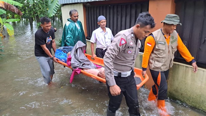 Petugas polisi membantu evakuasi warga yang rumahnya kebanjiran di Desa Jati Wetan, Kecamatan Jati, Kudus, Kamis (14/3/2024).